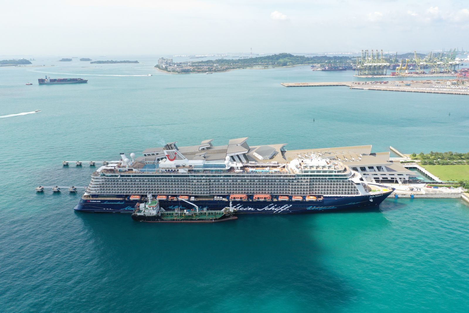 Aerial view of a cruise ship docked beside turquoise water, one of many sailings that can flex to fit a budget