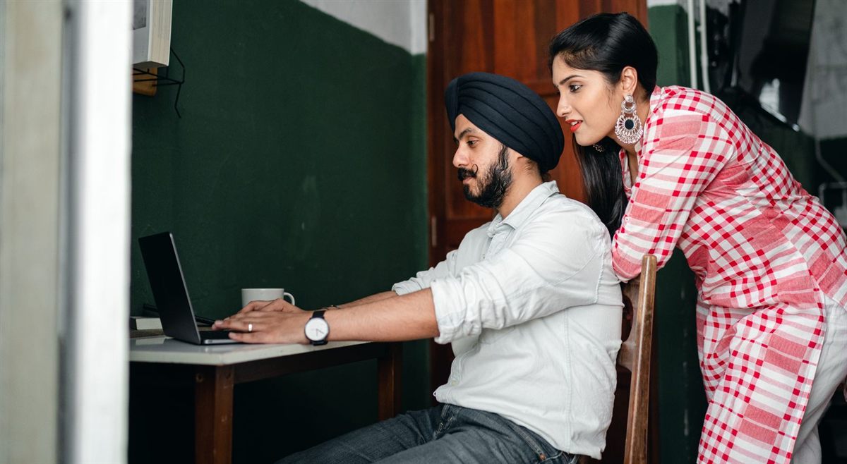 Two travelers at a desk working through a laptop together to settle their cruise budget