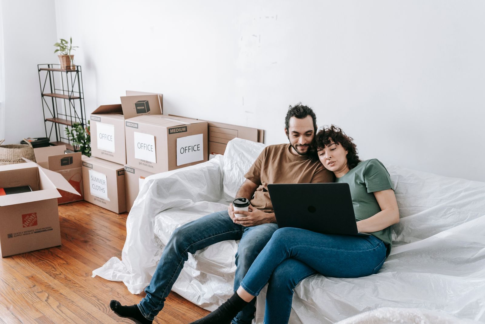 A couple relaxing on a sofa with a laptop, writing a name your price cruise request
